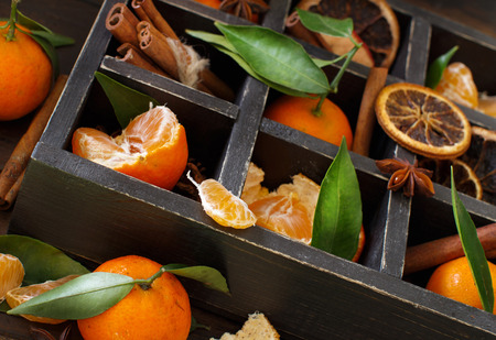 Mandarins  and spices in a box on a dark wooden backgroundの写真素材