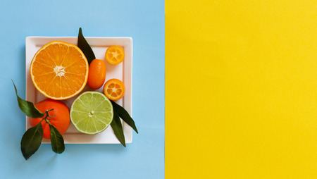 Citrus fruits on a blue and yellow background top viewの写真素材