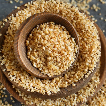 Dry bulgur wheat grains in bowls close upの写真素材