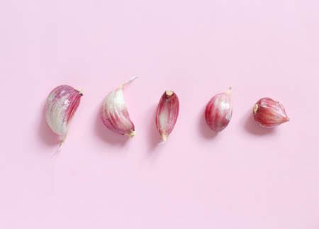 Fresh garlic on a light pink background top viewの写真素材