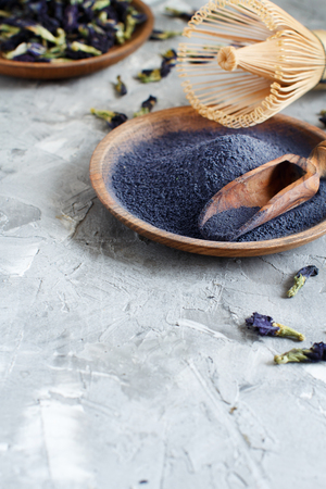 Butterfly pea blue matcha powder word with wrisk and dried flowersの写真素材