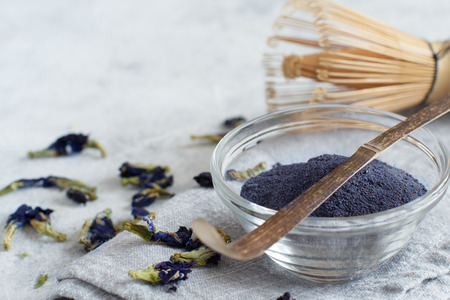 Butterfly pea blue matcha powder word with wrisk and dried flowersの写真素材