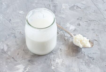 Fermented drink kefir in small bottle and kefir grains on a white background close upの写真素材