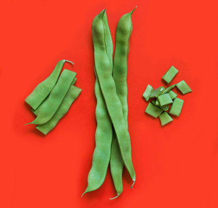 Piattoni green beans top view on a coral red background