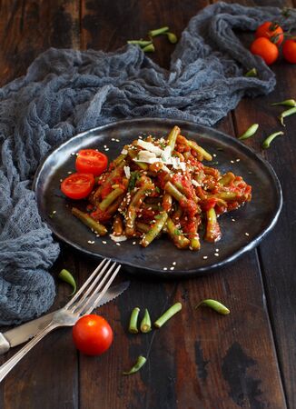 French beans with tomato stew close up on a dark tableの写真素材