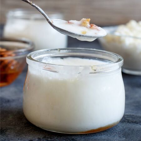 Fermented yogurt kefir in small bottles with cherries and walnuts close upの写真素材