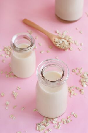 Vegan oat milk, non dairy alternative milk on a light pink backgroundの写真素材