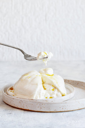 Italian cheese burrata on a plate with a fork