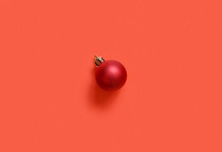 Red Christmas bauble on a red background top viewの写真素材
