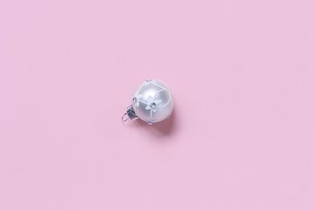 Silver Christmas bauble on a light pink background top viewの写真素材