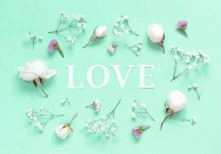 Flowers and word Love on a light green background top viewの写真素材
