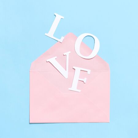 Word LOVE and pink envelope on a light blue background top viewの写真素材