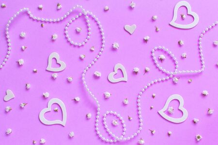 Spring composition with flowers, hearts and pearls on a pink backgroundの写真素材