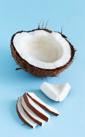 Coconut pieces on a light blue background close up
