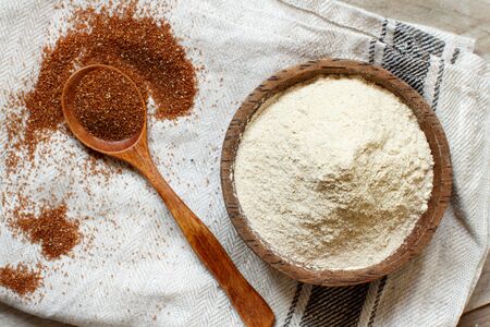 Teff flour in a bowl and teff grain with a spoon top viewの写真素材