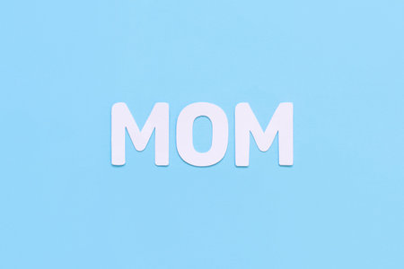 Letters MOM on a light blue background top view