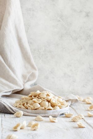 Fresh raw apulian pasta orecchiette made from whole wheat flour on a wooden table close upの写真素材