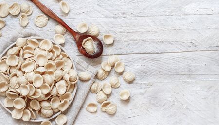 Fresh raw apulian pasta orecchiette made from whole wheat flour on a dark table top viewの写真素材