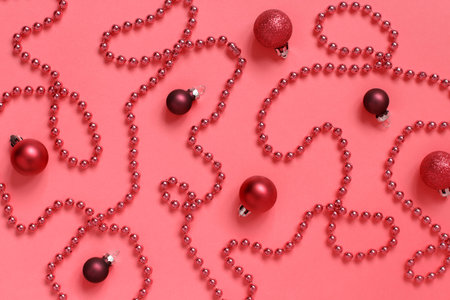 Red Christmas garland and baubles on a red background top view