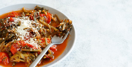 Healthy Sauteed green cicory and tomatoes topped with caccioricotta cheese close upの写真素材
