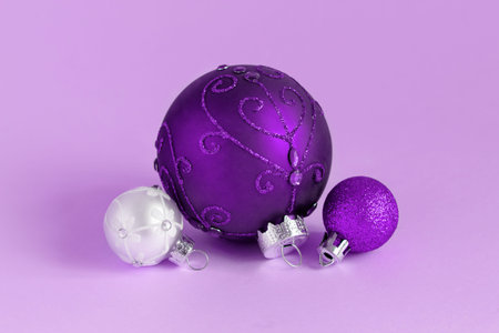 Purple and silver Christmas baubles on a lavender background close upの写真素材