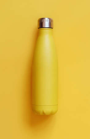 Close-up of yellow reusable steel bottle on yellow backgroundの写真素材
