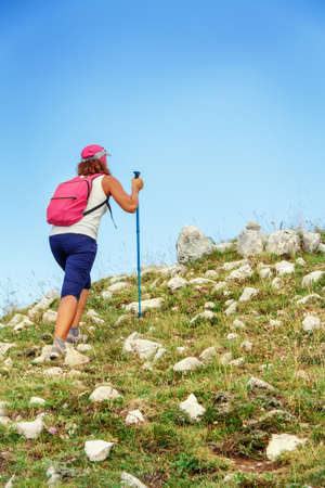 Women hiking in mountains in a sunny dayの写真素材