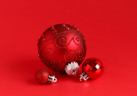 Red Christmas baubles on a red background close up