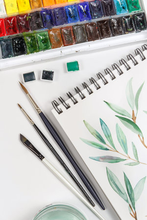 Drawings, brushes, palette and watercolor paints top view. Workplace of artistの写真素材