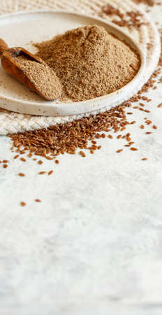 Raw Flax seeds flour in a ceramic plate with a spoon close upの写真素材