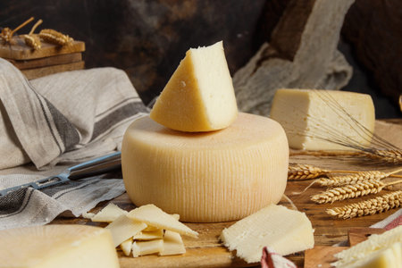 Pieces of  fresh homemade cheese on a wooden board with a knife  close up