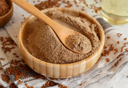 Raw Flax seeds flour in a wooden bowl with a spoon close upの写真素材