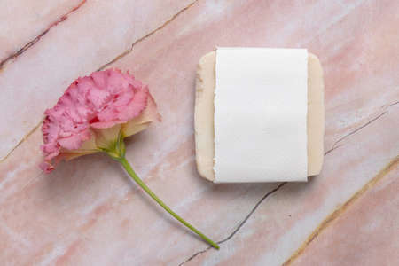 Soap bar on laying on a marble table with pink flower, top view. Soap mockupの写真素材