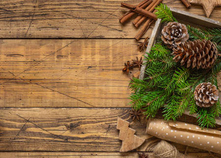 Winter Christmas Composition with a copy space on wooden table flat lay. Christmas and New Year decorations with fir branches and pine cones top view.の写真素材