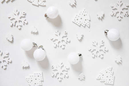 White Christmas baubles and snowflakes on white table top view. Monochrome winter composition with holiday decorationsの写真素材