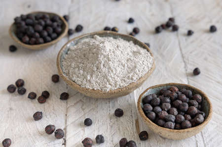 Porcalain bowls of black chickpea flour and beans closeup on white wooden table. Traditional beans from Apulia and Basilicata in Italyの写真素材