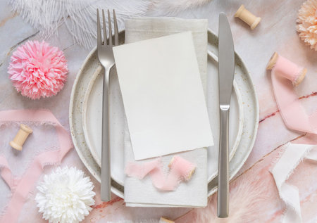 Wedding Table place with a blank card near flowers, silk ribbons and feathers, top view. Romantic...