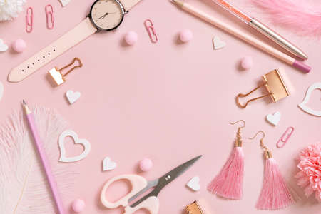Pink school accessories and hearts on pastel pink, Top view, copy space. Girly workplace with scissors, pencils, pen, paperclips, earrings and watch. Valentines Day and Back to school conceptの写真素材