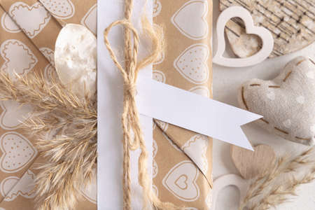 Valentines present with horizontal gift tag, heart and pampas grass close up. Spring scene with blank label. Rustic, cottage chic or bohemian mockup, copy spaceの写真素材