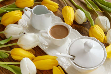 Elegant Coffee tray near white and yellow tulips on wooden table close up. Romantic breakfastの写真素材