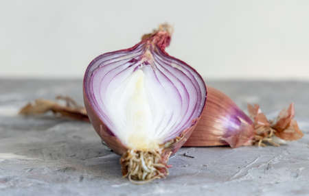 Half of Red tropea onions on a grey  table close up. Traditional local south italian vegetable. Cooking process in home kitchenの写真素材
