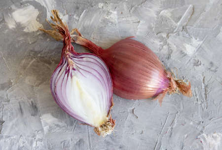 Half of Red tropea onions on a grey  table close up. Traditional local south italian vegetable. Cooking process in home kitchenの写真素材