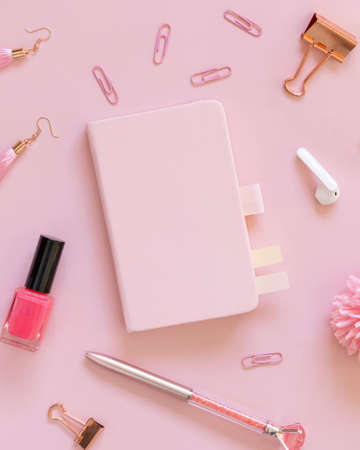 Hardcover notebook and Pink school accessories on pastel pink, top view, textbook mockup. Girly workplace with scissors, pencils, pen, paperclips, earrings and watch. Back to school conceptの写真素材