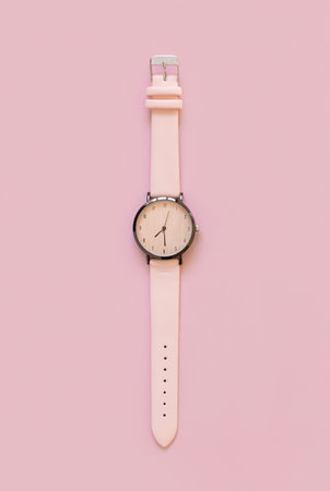 Pink wristwatch on pink, Fashion girly or Elegant femminine accessory top view. Time concepts