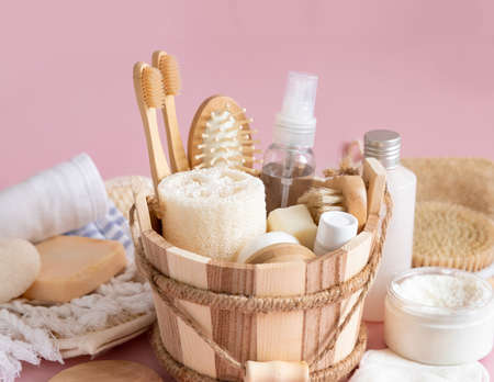 Sauna bucket with organic natural cosmetics and zero waste reusable accessories for skin and hair care on pink. Close up of eco friendly beauty products for bath, massage or spa salonの写真素材