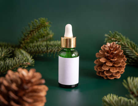 Green Pipette Dropper Bottles with blank label near fir branches and pine cones close up. Brand packaging mockup. Skincare beauty product, cream or serum. Natural cosmetics conceptの写真素材