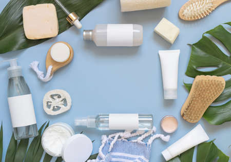 Homemade Cosmetics, eco friendly accessories, and tropical leaves on blue flat lay, copy space. Brand packaging mockup. Natural beauty products for hair and skin care, Top viewの写真素材