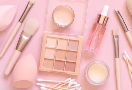 Skin care and makeup products on light pink, top view, banner. Flat lay with natural beauty products and decorative cosmetics. Everyday woman face care routine. Pastel compositionの写真素材
