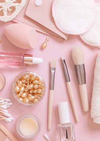 Skin care and makeup products on light pink, top view. Flat lay with natural beauty products and decorative cosmetics. Everyday woman face care routine. Pastel compositionの写真素材
