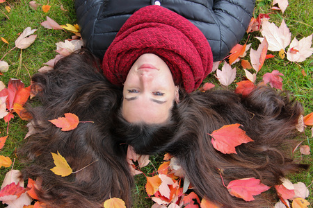 Beautiful girl long dark hair decorated with autumn leavesの写真素材
